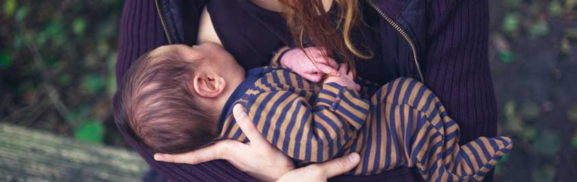 Woman breastfeeding baby outside