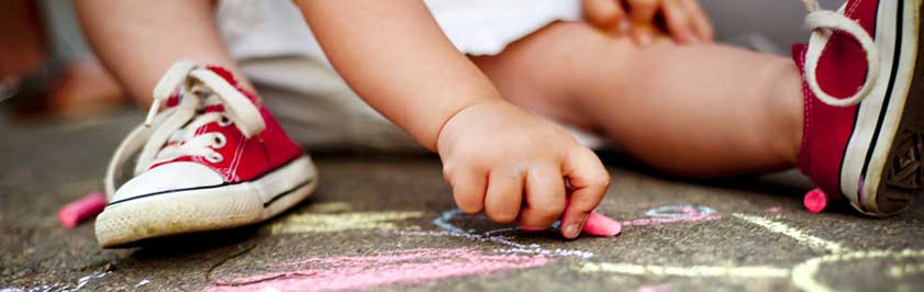 boy drawing on pavement with chalk